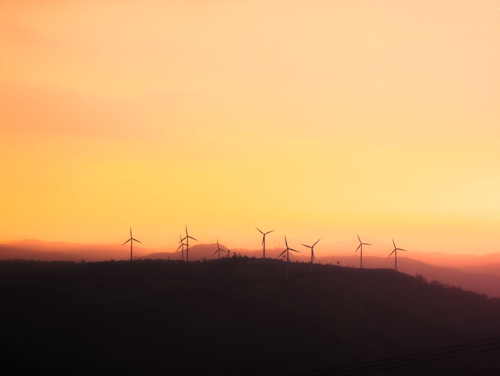 Tuulivoimaloiden siluetit auringonlaskussa