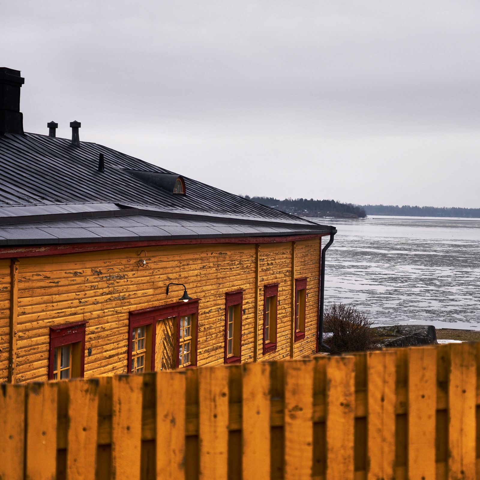 Puinen talo talvisen meren rannalla