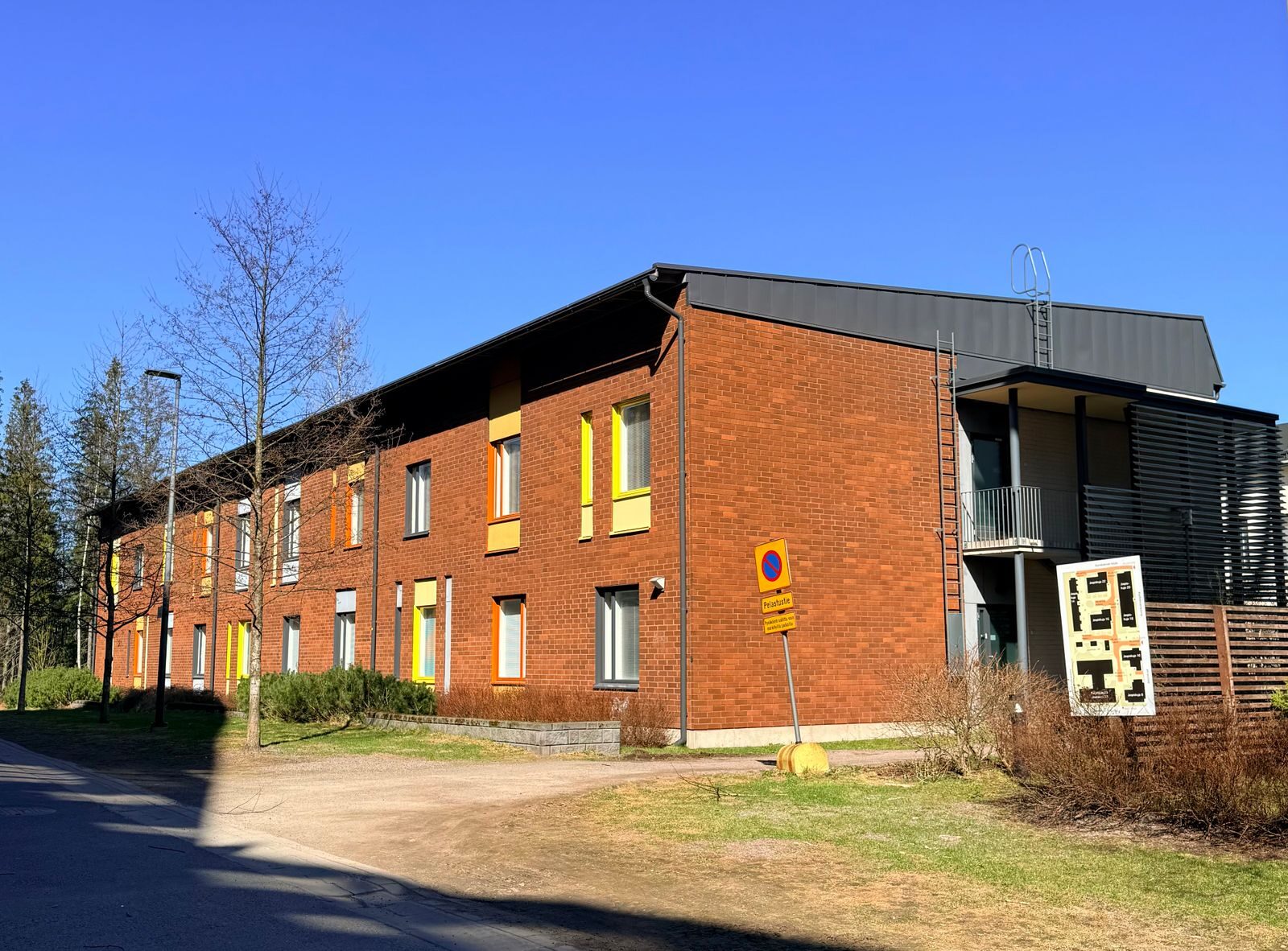 Punatiilinen asuinrakennus aurinkoisena päivänä