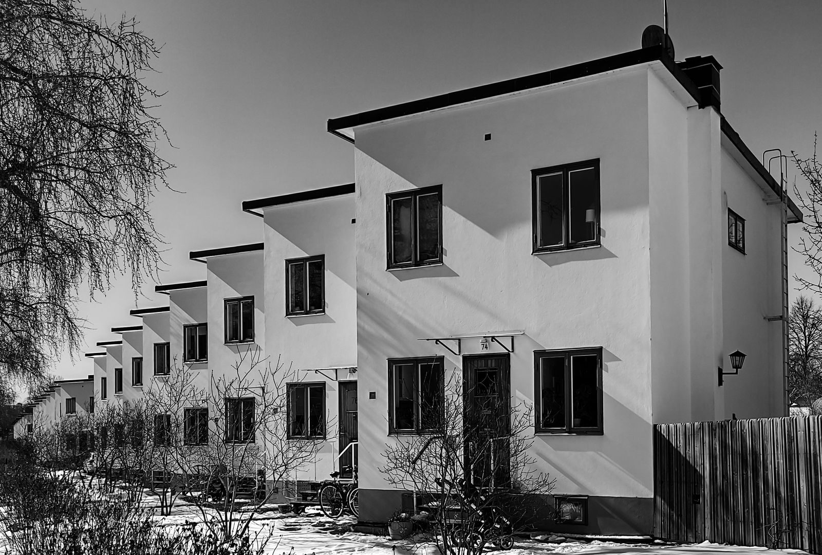 Vierekkäisiä kaksikerroksisia rivitaloasuntoja kadun varrella.